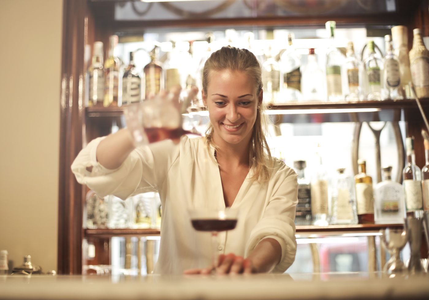 A bartender pouring a drink behind the bar