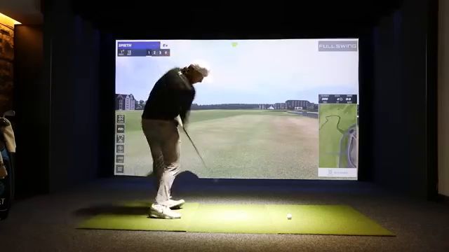 Golfer swinging in a simulator bay